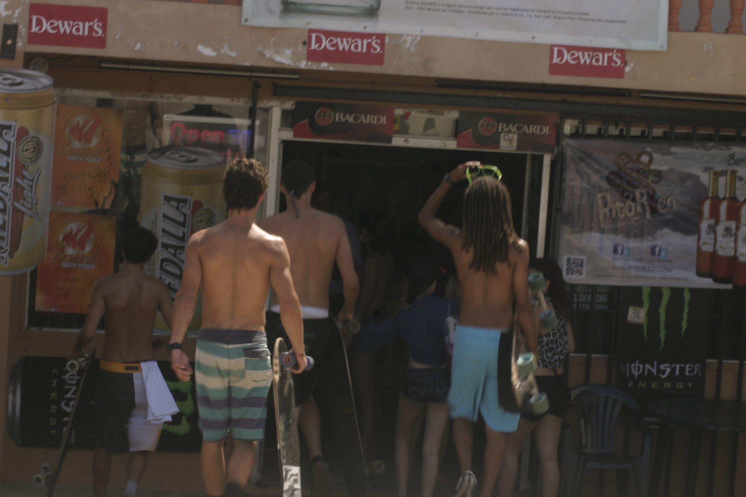 Young surfers grab a drink at a Jobos Beach bar