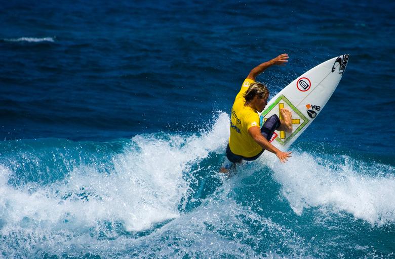 Surfer with yellow top riding a wave off Isabela, Puerto Rico